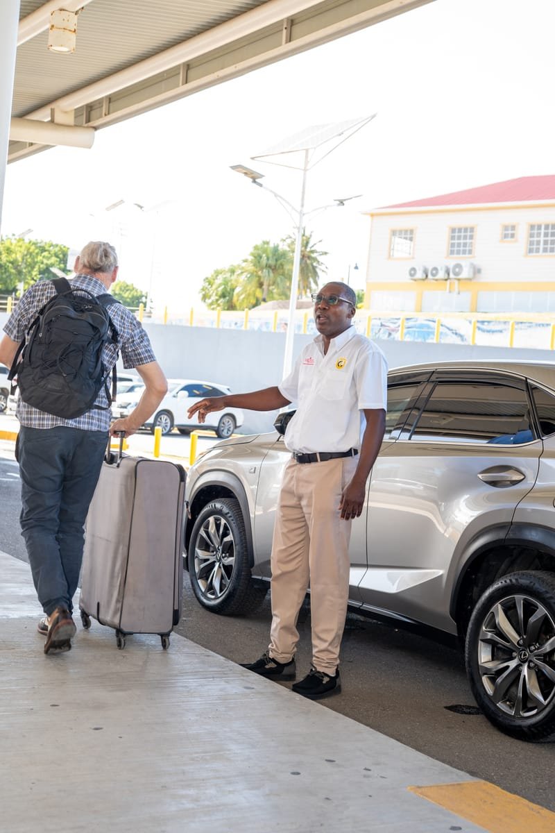 AATA driver welcoming a passenger at V.C. Bird International Airport