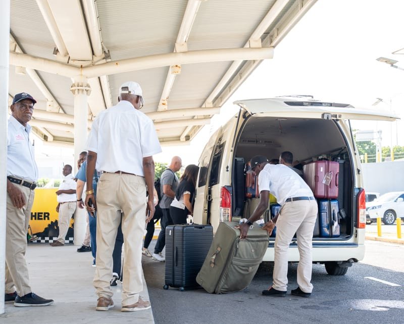 Team loading luggage into shuttle van
